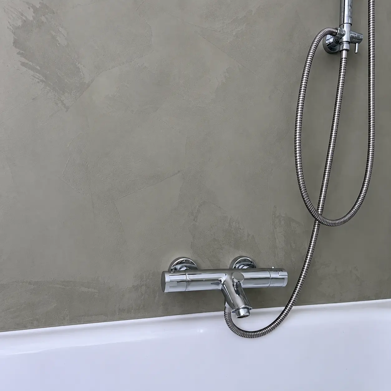 Badezimmerwand mit grauer Beton-Ciré-Oberfläche