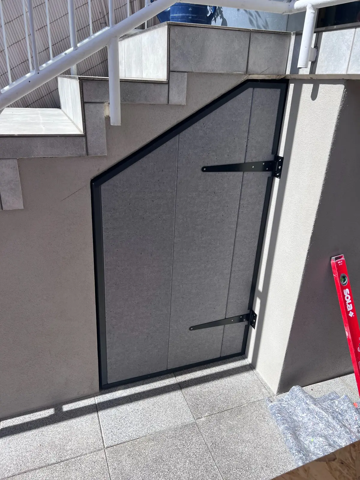 Maßgefertigte Tür und Wandverkleidung unter einer Treppe